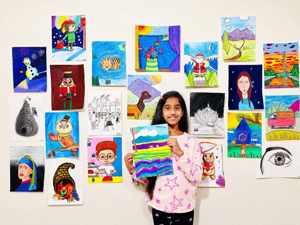 Young girl proudly displaying her artwork from Nimmy's Art.