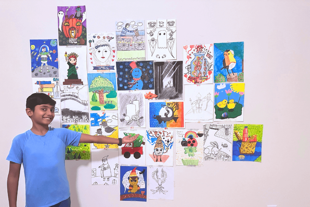 Young artist Yashwanth displaying his collection of artworks from Nimmy's Art Class, showcasing his artistic talent and development.