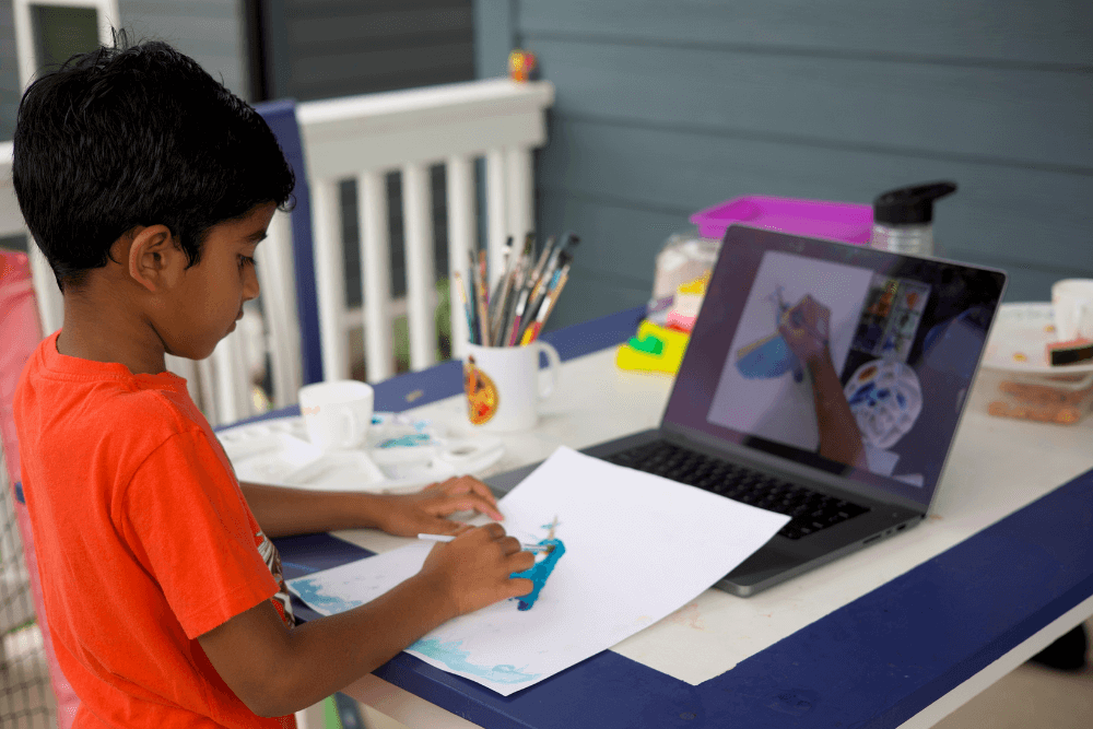 Young artist George focusing on drawing and painting a vibrant kingfisher during an art class