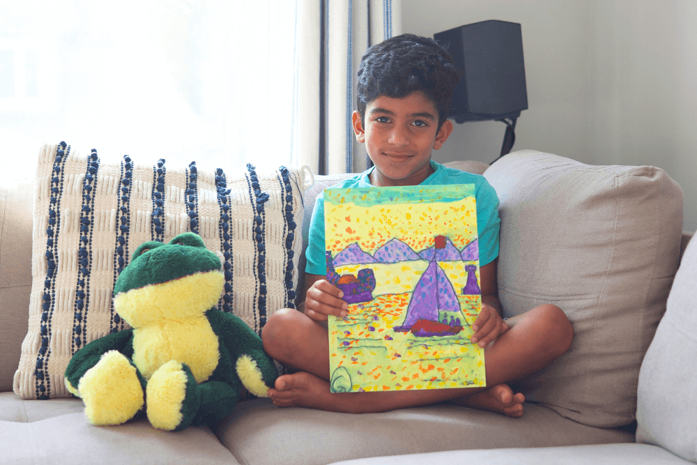 George proudly holding his acrylic painting of a vibrant fisherman's boat at the shore. The painting showcases colorful details of the boat, water, and sky.