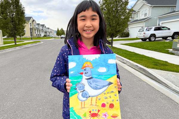 Bella proudly holds her colorful painting of a mother hen and chick from the Summer Art Camp, smiling with excitement.