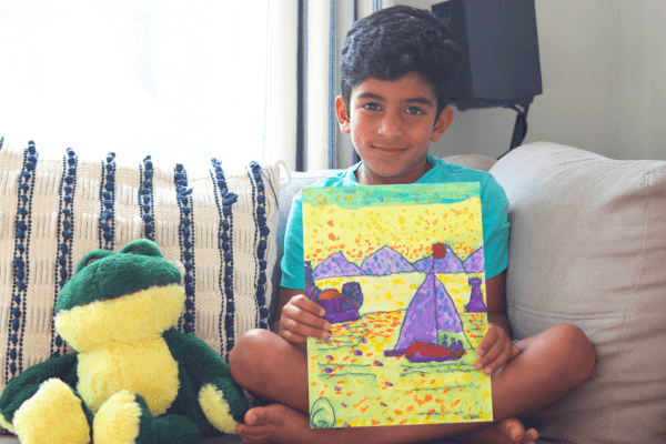 George proudly holds his acrylic painting of a sea with a fisherman’s boat, created using dot techniques during the Summer Art Camp