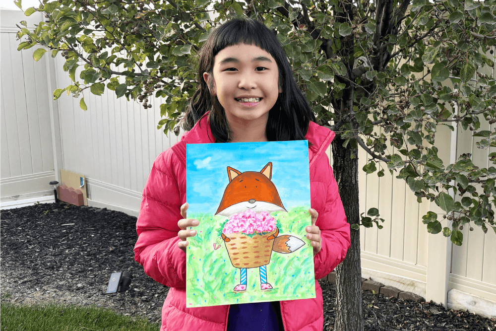 Bella proudly holding her Valentine's Day painting of a fox with a basket of flowers, showcasing her artistic skills.